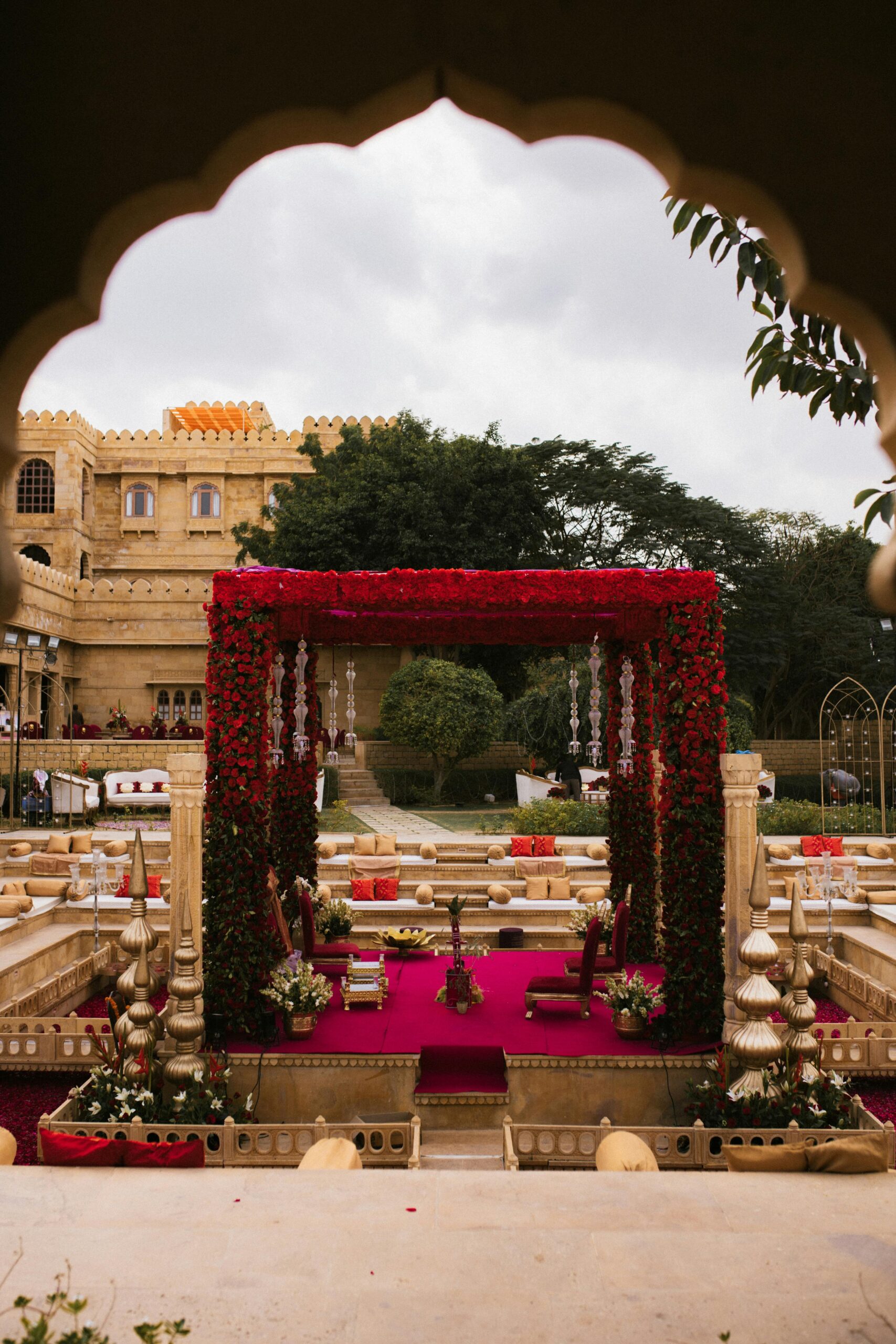 Ornate mandap setup in outdoor historic fort for an Indian wedding ceremony.
