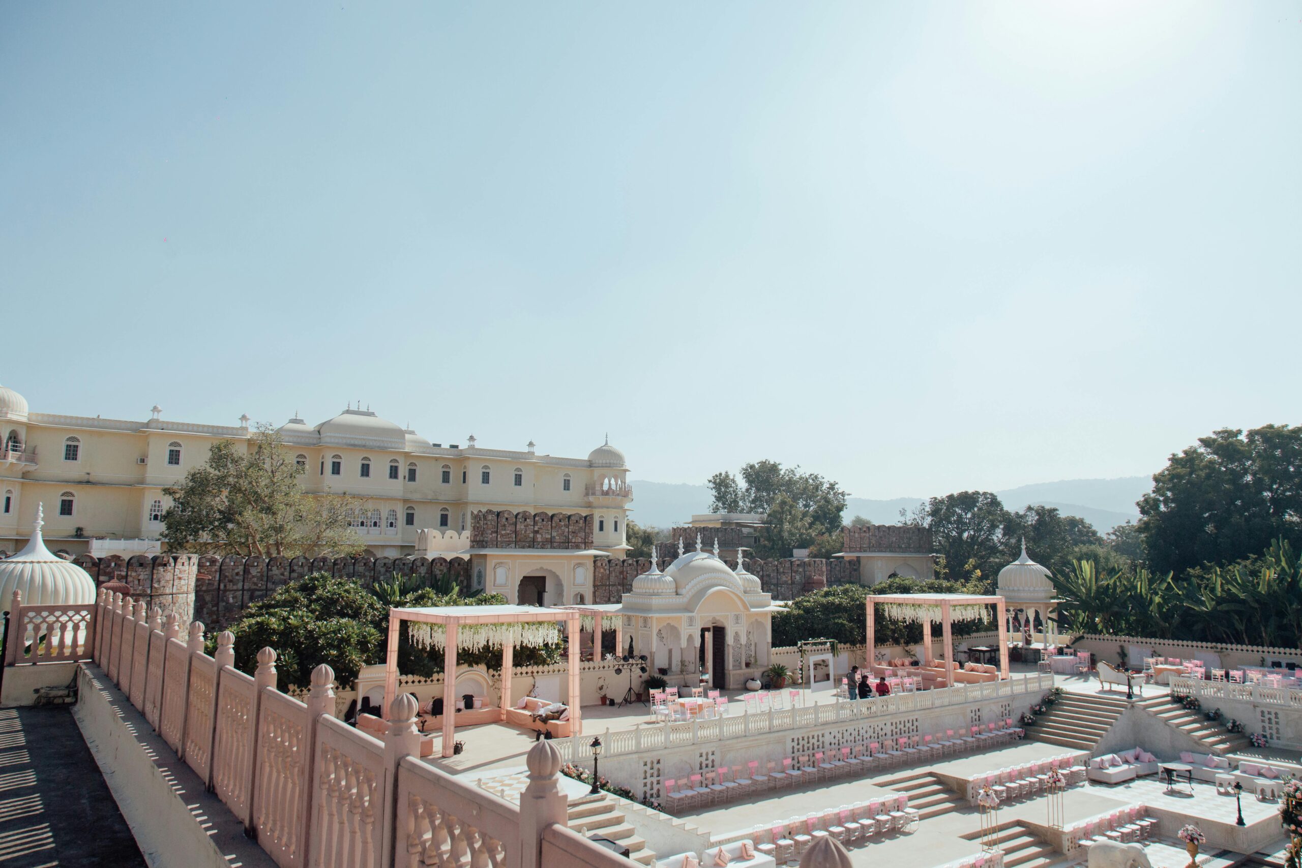 Beautiful outdoor wedding setup in an Indian palace courtyard on a sunny day.